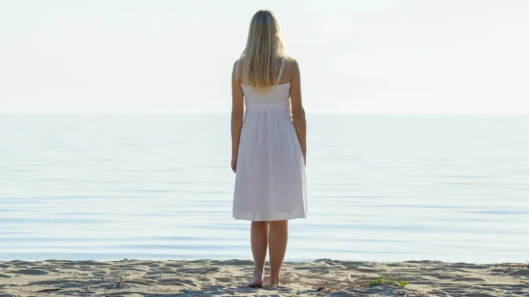 woman looking at ocean alone